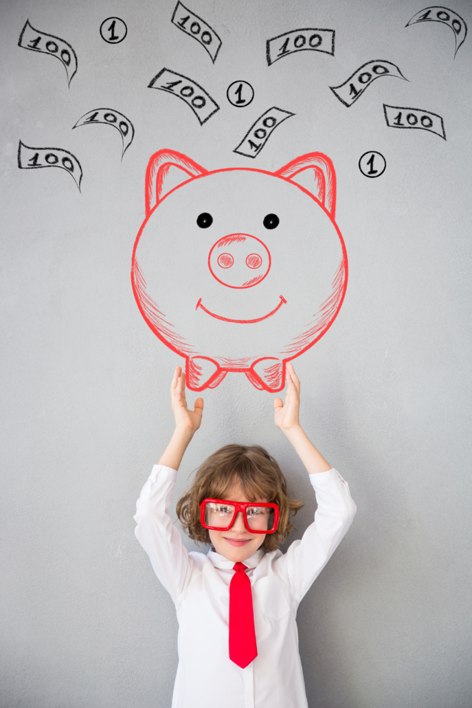 Child pretending to be businessman. Piggy bank with money drawn on marker board behind him.